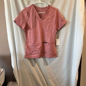 NWT women’s XS Jaanuu scrub top in pink. Short sleeve, v neck, 2 front pockets